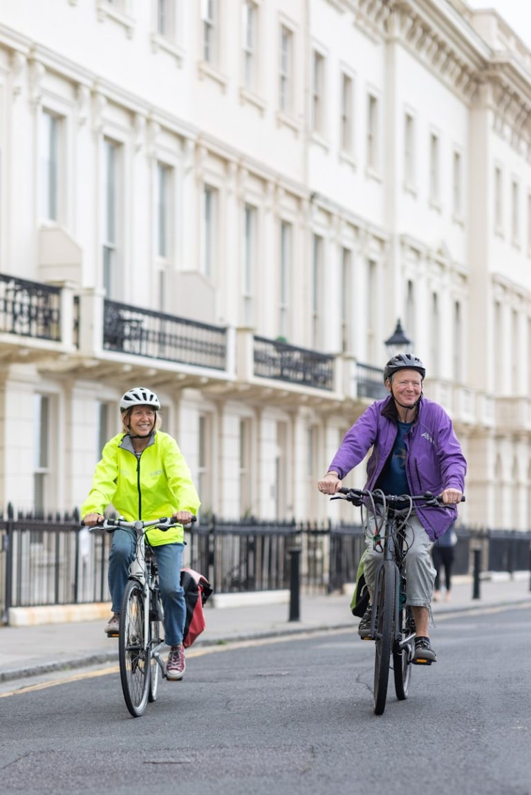 a couple of people riding bikes down a street